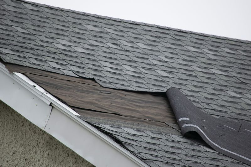 Close-up of asphalt shingles being repaired